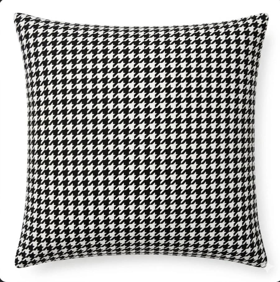 Grey and white houndstowth velvet throw pillow with black and white checkered pattern and visible piping on edges.