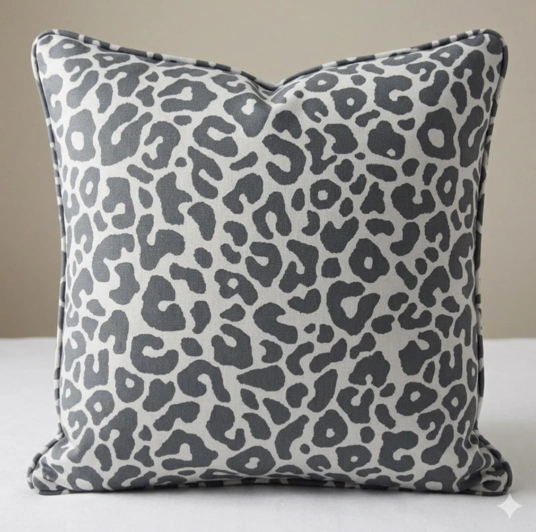 Light grey square decorative cushion with black leopard print pattern and matching stitched edges.