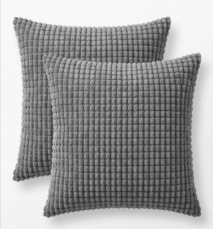 Two textured grey throw pillow covers with small black circular pattern, 22/22 size, on white background.