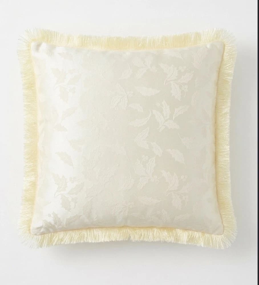 Square cream Damask Holly cushion with gold fringe, floral pattern, and satin fabric.