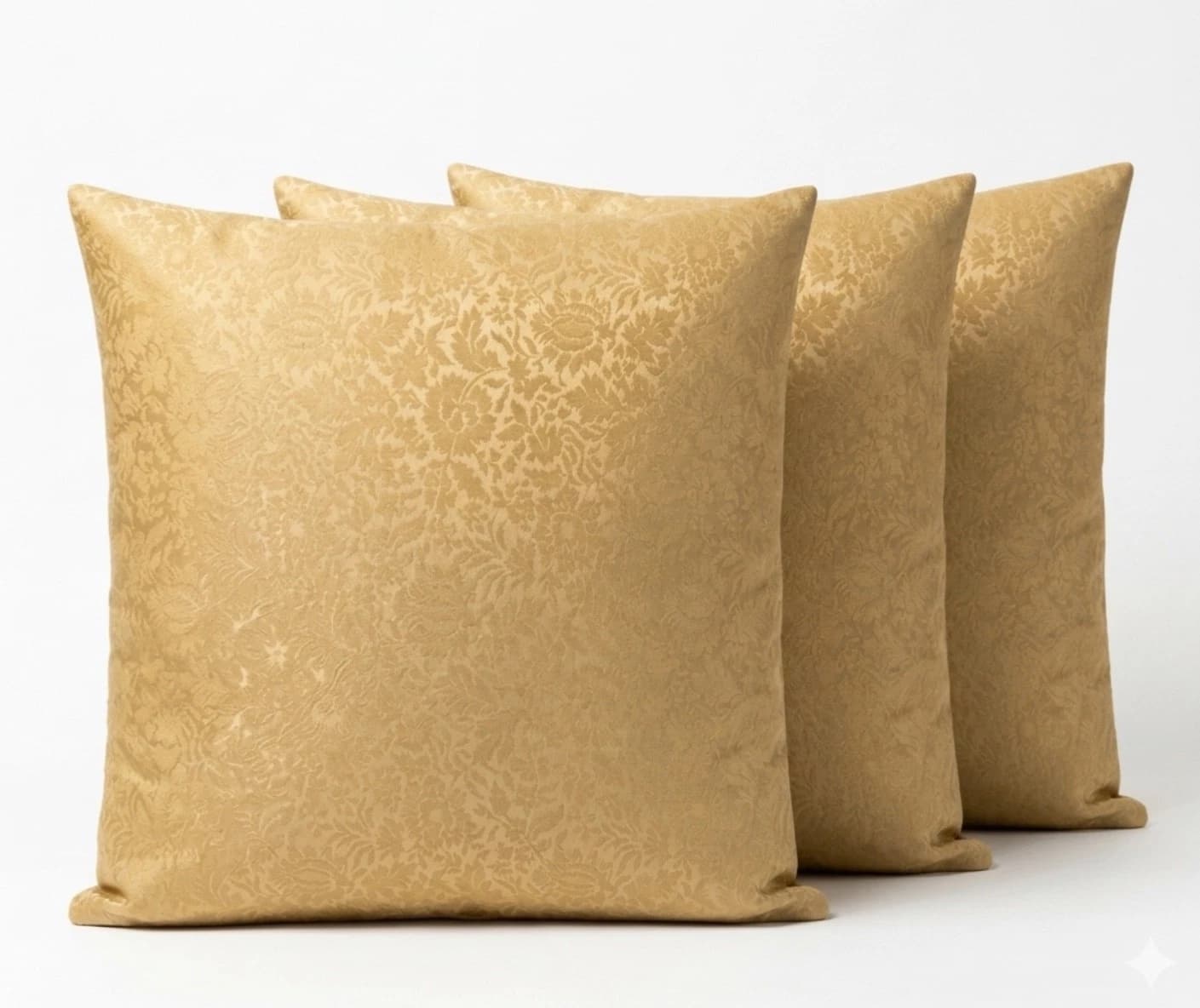 Three square beige throw pillows with intricate embossed floral and foliage patterns on a textured light fabric background.
